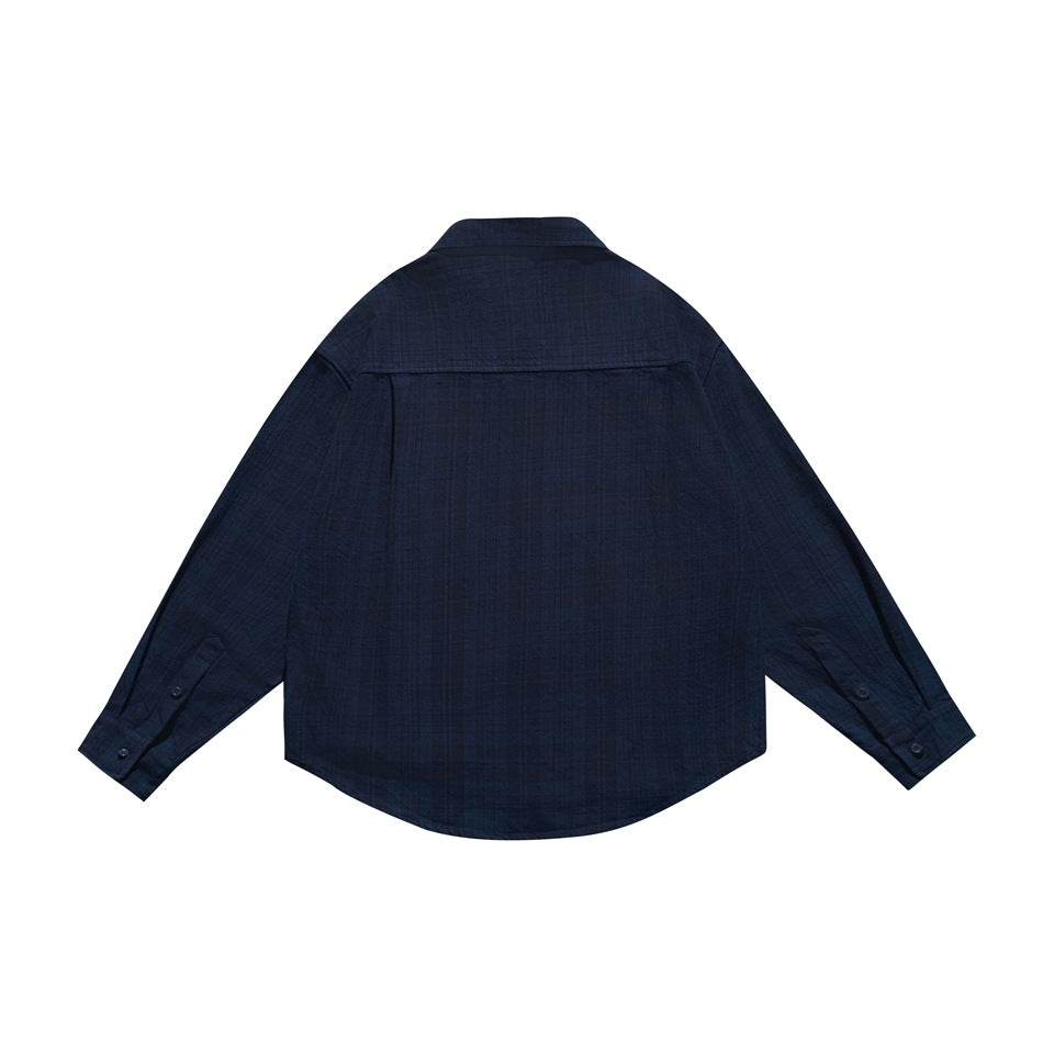 Back view of a dark navy long-sleeve shirt with a yoke seam, button cuffs, and curved hem.