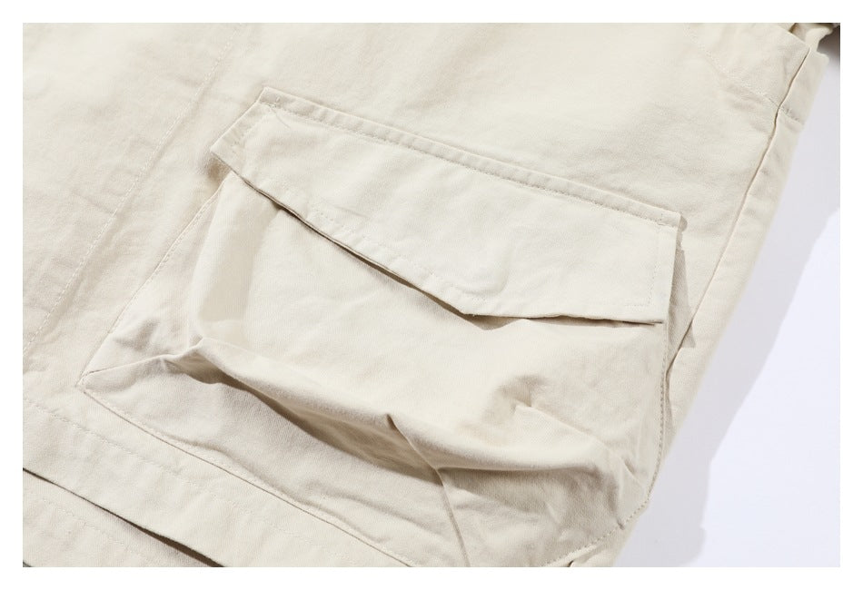 Close-up of a large flap pocket on an ivory garment.