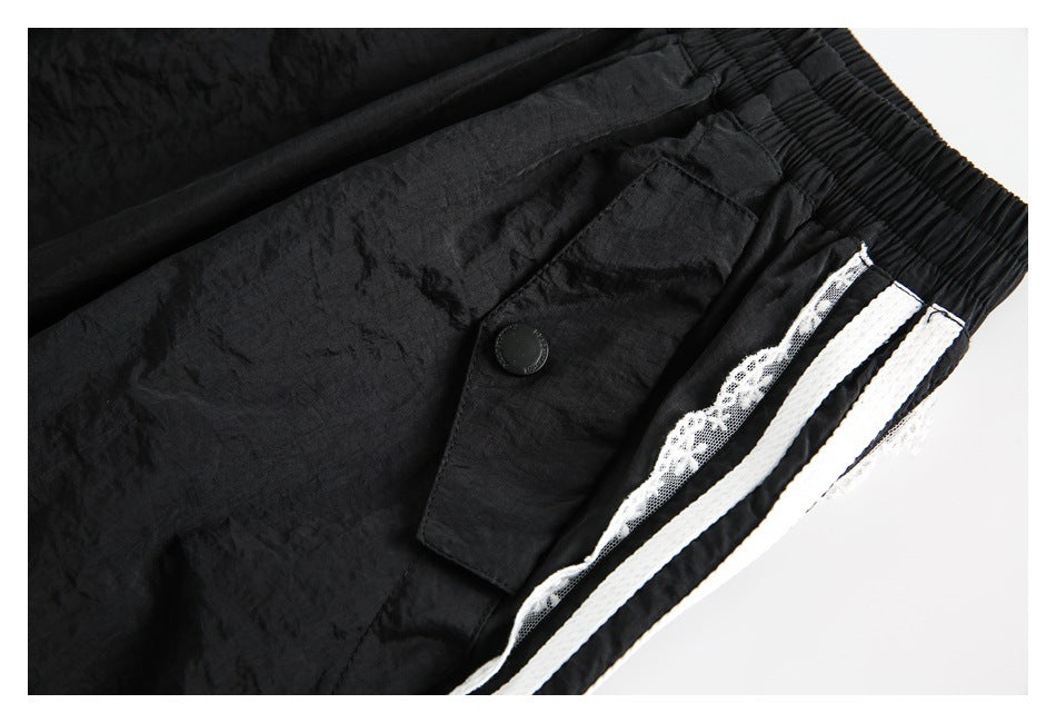 Angled close-up of a black skirt's buttoned pocket flap and white striped lace side trim.