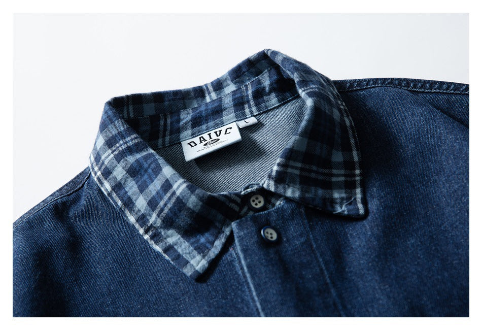Close-up of a dark blue denim shirt collar with blue, black, and gray plaid lining and a sewn neck label.