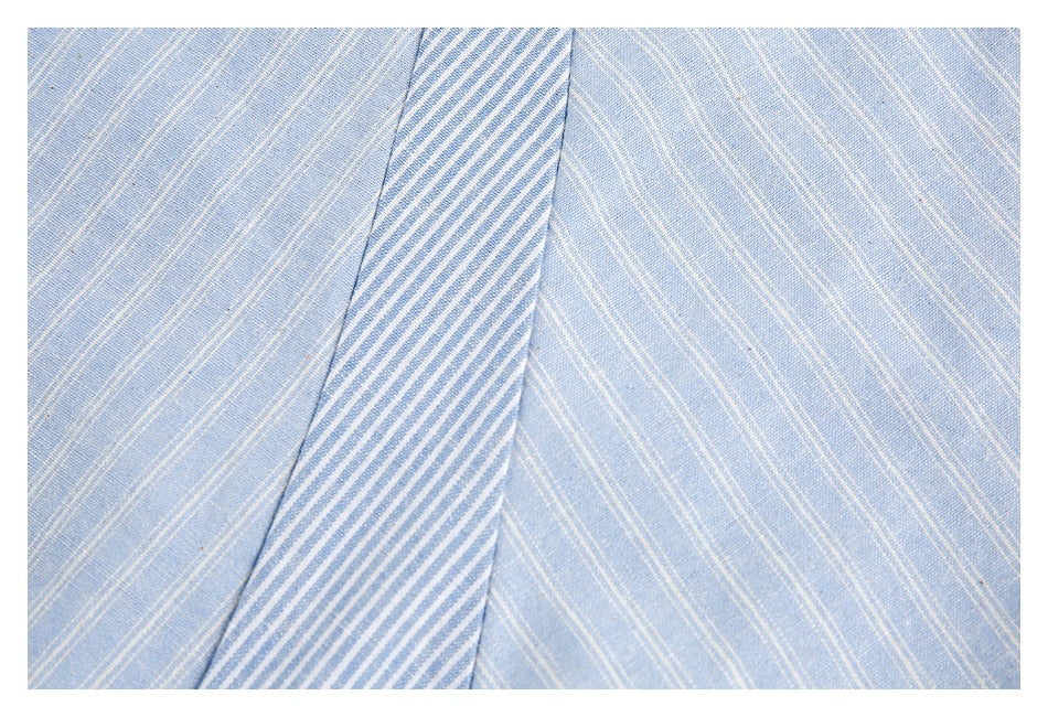 Close-up of a narrow blue-and-white striped shirt panel against light blue pinstriped fabric.