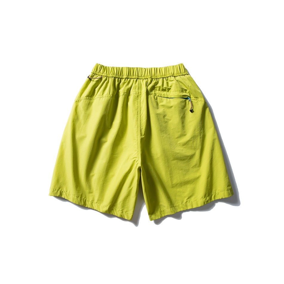 Bright yellow-green shorts shown from the back, with an elastic waistband and a zippered rear pocket.