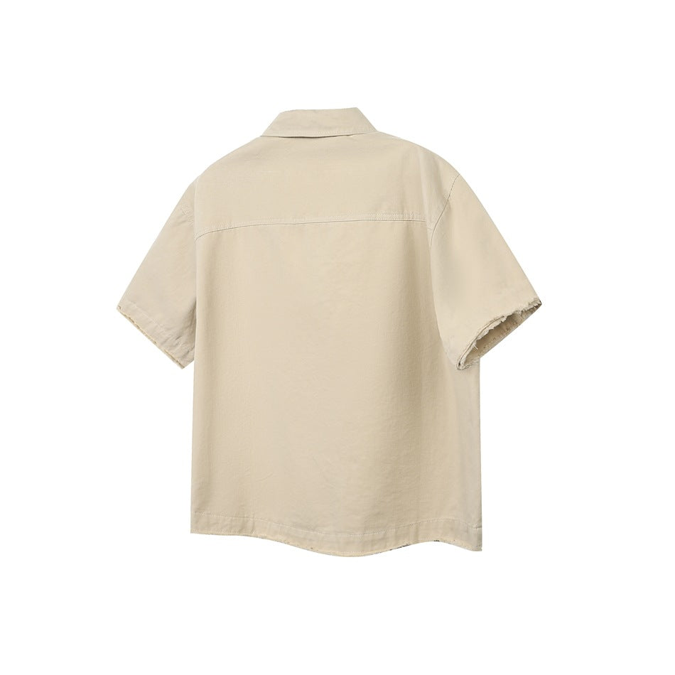 Back view of a beige short-sleeve collared button-up shirt with a straight yoke seam and raw sleeve edges.