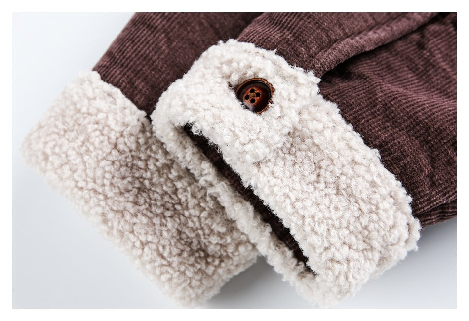 Close-up of a plum-brown jacket cuff with thick cream sherpa lining and a brown button.