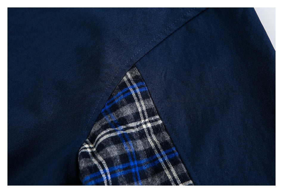 Close-up of a gray, white, and blue plaid inset between dark navy garment panels.