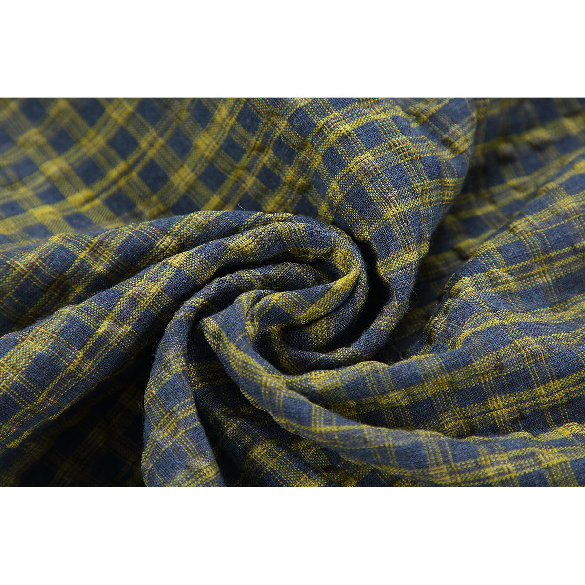 Close-up of blue-gray fabric with a mustard plaid pattern, gathered to show its texture.