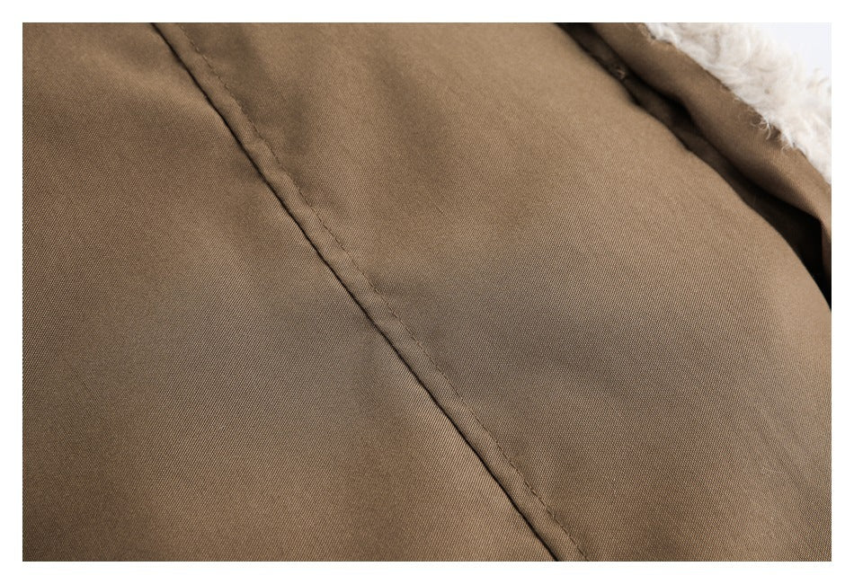 Close-up of brown fabric with a seam and a glimpse of white fluffy lining.