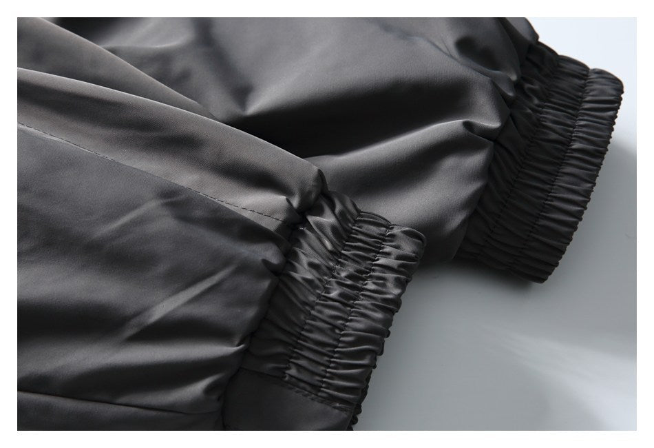 Close-up of gathered elastic cuffs on a dark charcoal garment.