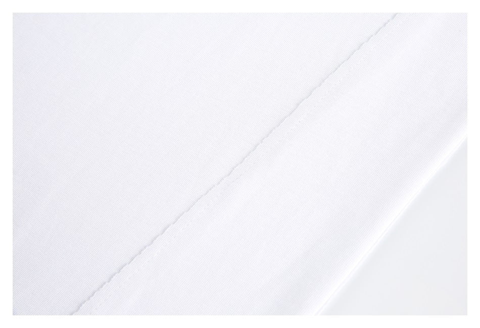 Macro view of plain white garment fabric and a diagonal stitched seam.