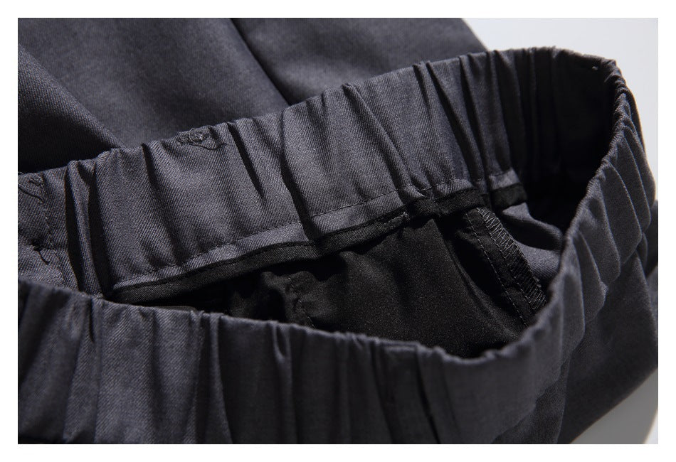 Interior close-up of charcoal trousers showing the gathered waistband and finished seams.