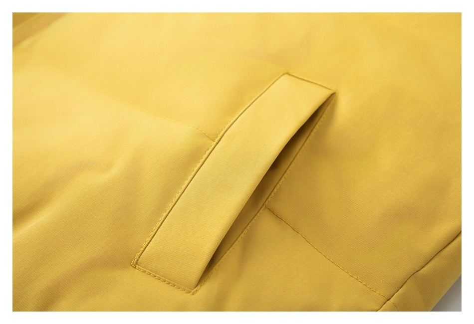 Close-up of the mustard-yellow jacket's angled welt pocket opening and stitching.