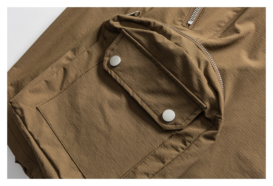 Close-up of a brown garment pocket with a snap-button flap and a visible metal zipper.