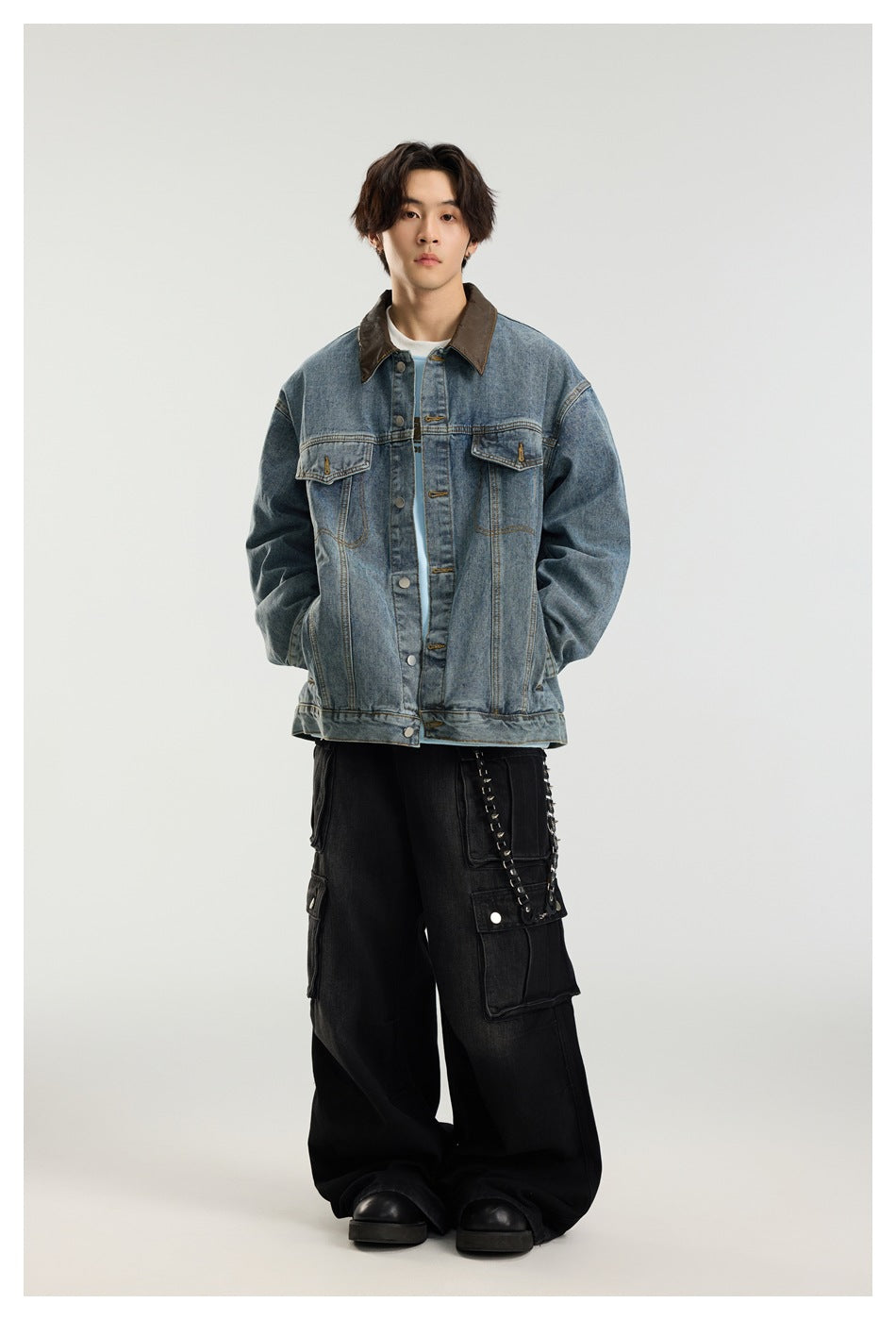 Model wearing a blue denim jacket with brown collar over a light blue top with wide black cargo pants
