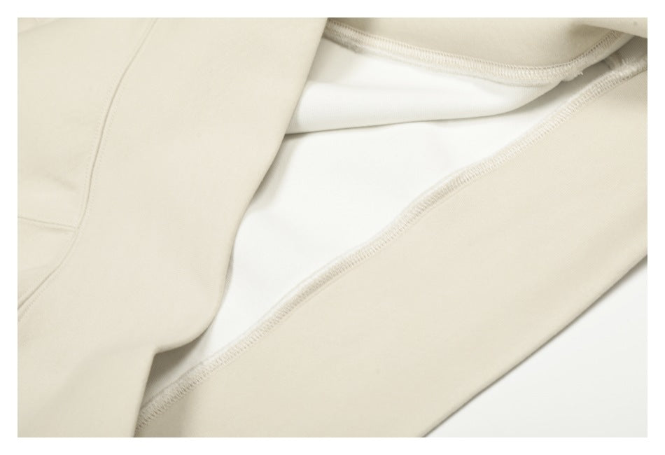Close-up of the cream hoodie’s inside seam and fabric layers.