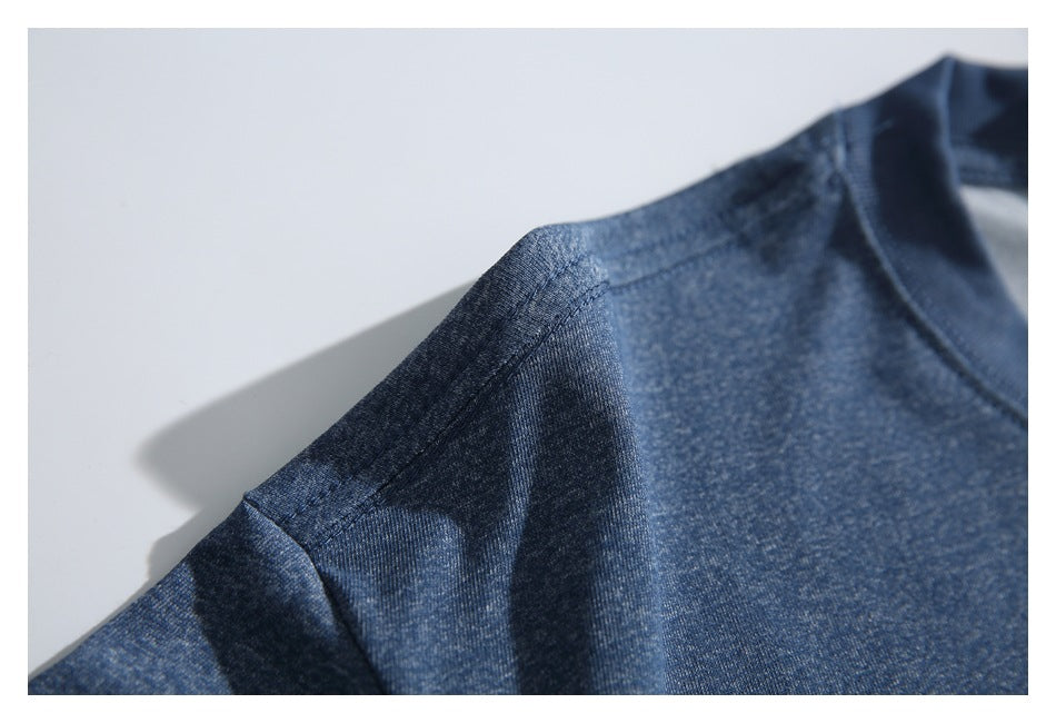 Close-up of the blue T-shirt's shoulder seam and heathered fabric.