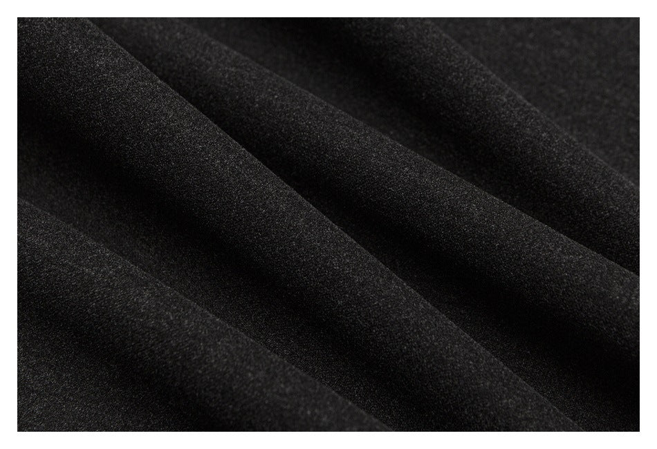 Macro view of the dark charcoal trouser fabric and its textured surface.