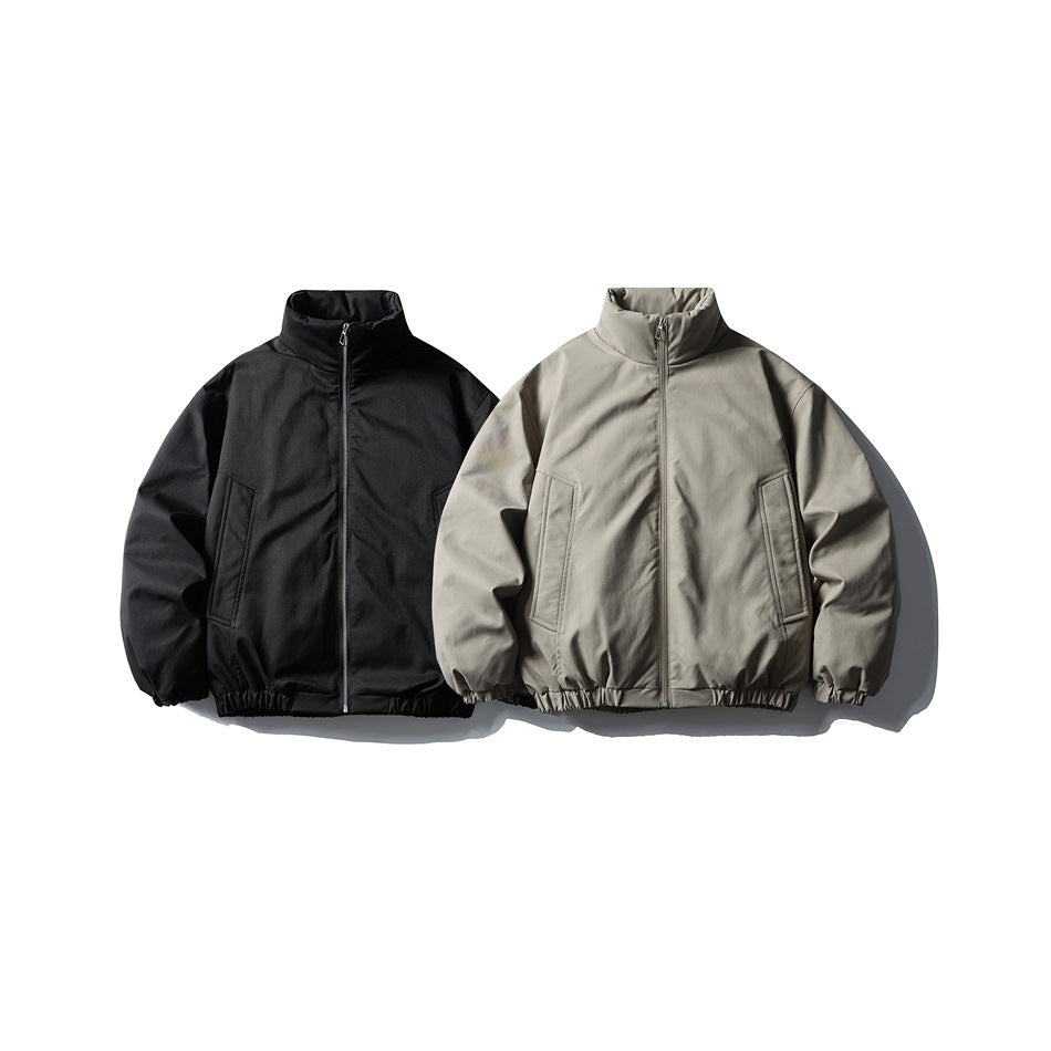 Two front-view stand-collar zip jackets with elastic hems, one black and one gray-beige.