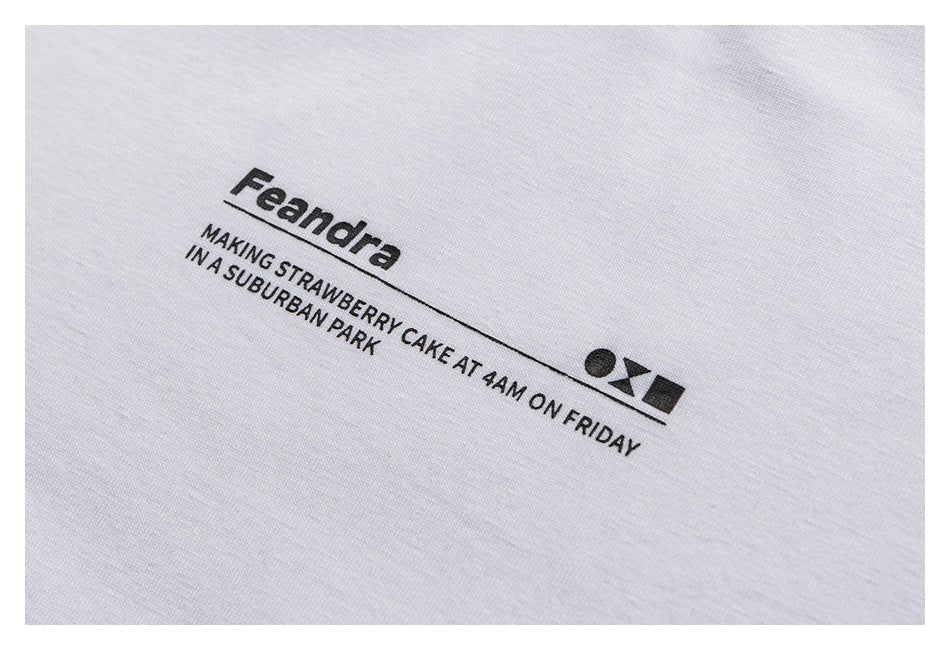 Close-up of black Feandra lettering and slogan printed on white T-shirt fabric.