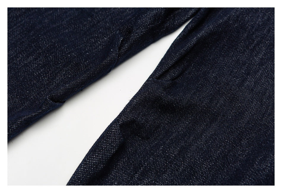 Close-up of dark indigo denim legs arranged at an angle against a white background.