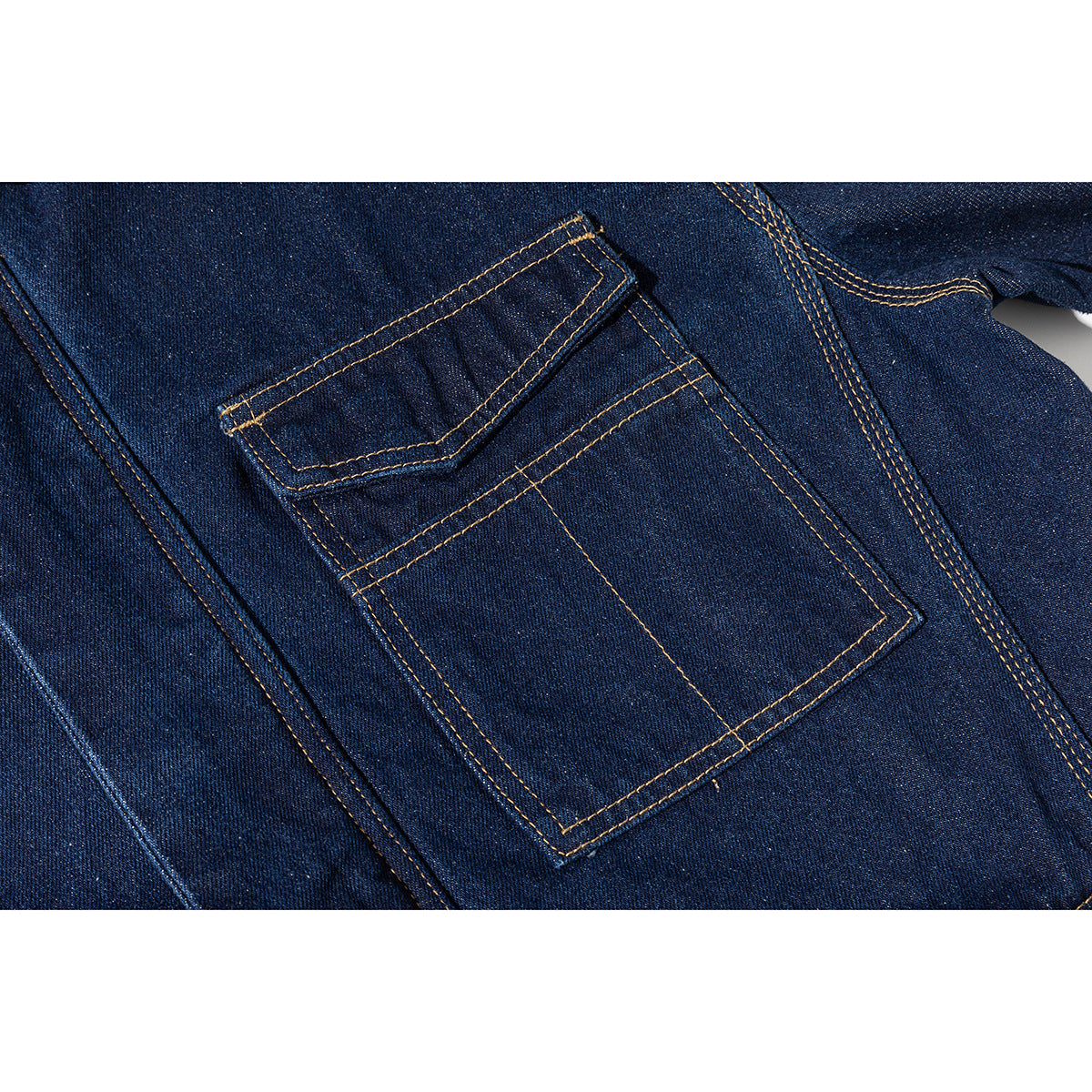 Close-up of a dark blue denim jacket's layered chest pocket with contrasting golden stitching.