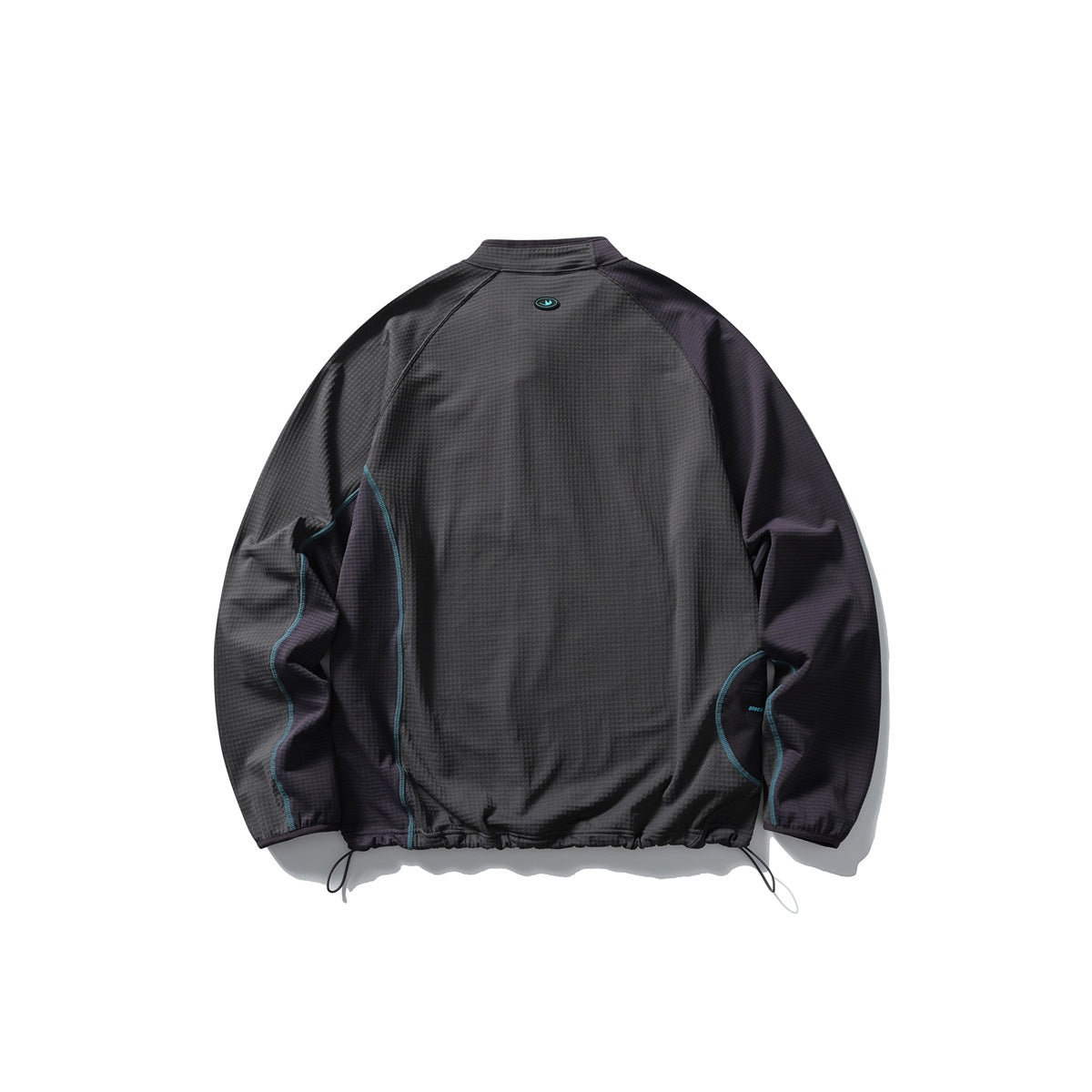 Back view of a charcoal jacket with dark contrast sleeves, teal piping, a small oval emblem and adjustable drawcord hem.