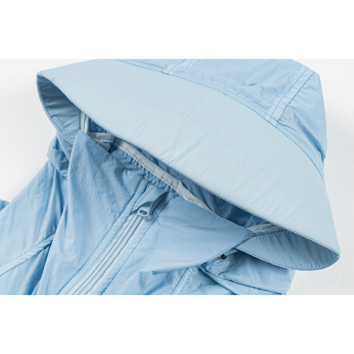 Close-up of a light blue jacket hood with a wide brim and front zipper.