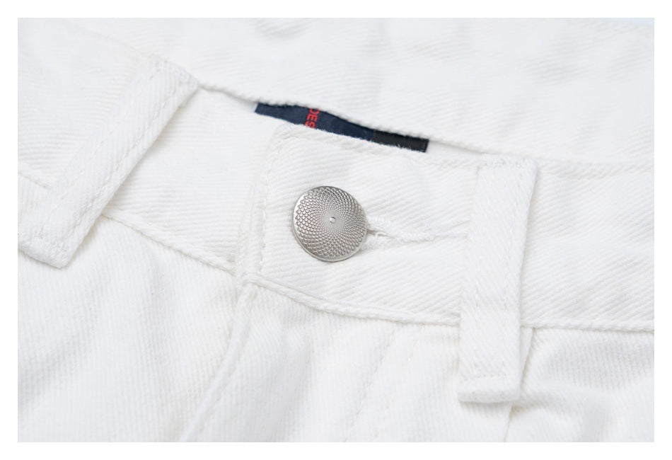 Close-up of the white jeans' waistband button, belt loop, stitching, and a partly visible inner label.