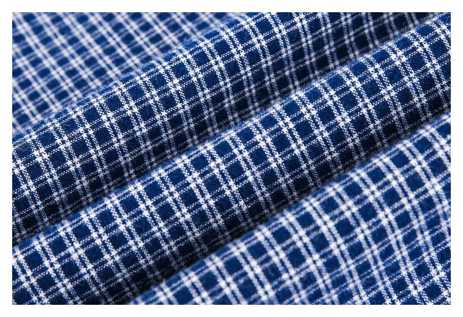 Close-up of navy blue fabric with a white windowpane plaid pattern and a softly textured weave.