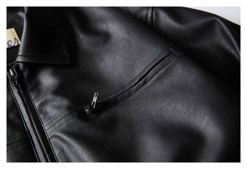 Close-up of a black jacket's slanted zip pocket and front zipper.