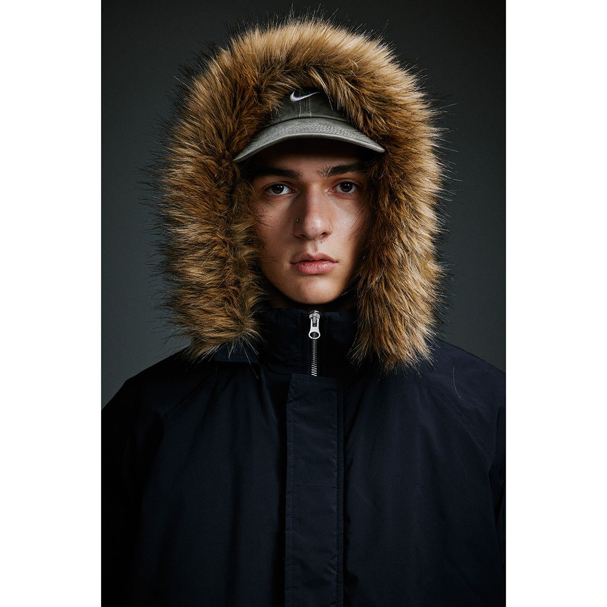 Close-up of the parka's brown fur-trimmed hood, high zipped collar, and dark fabric.