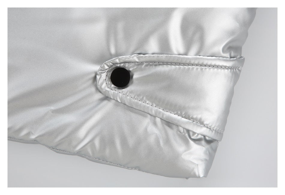 Close-up of a silver garment cuff with a black snap button and visible stitching.