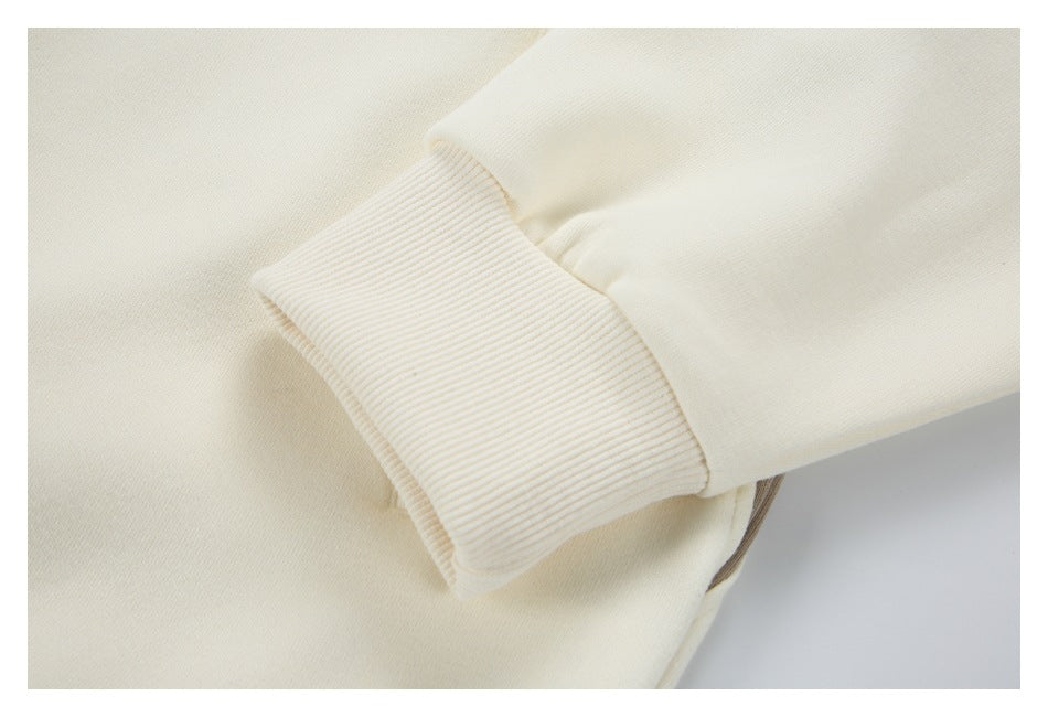 Close-up of a cream sleeve with a wide ribbed cuff.