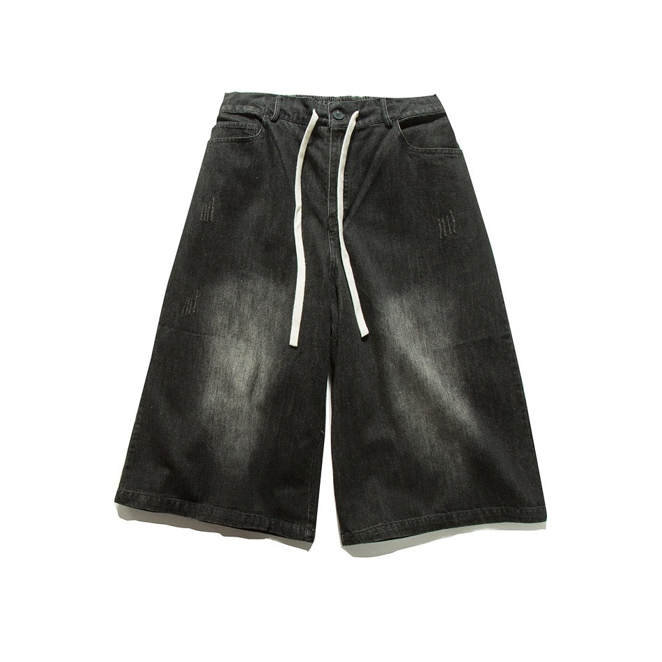 Black washed denim wide-leg knee-length shorts with white drawstring, flat lay front view