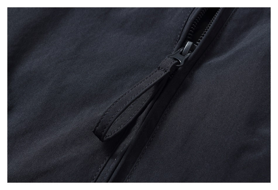 Close-up of a dark garment's zipper and stitched zipper flap.