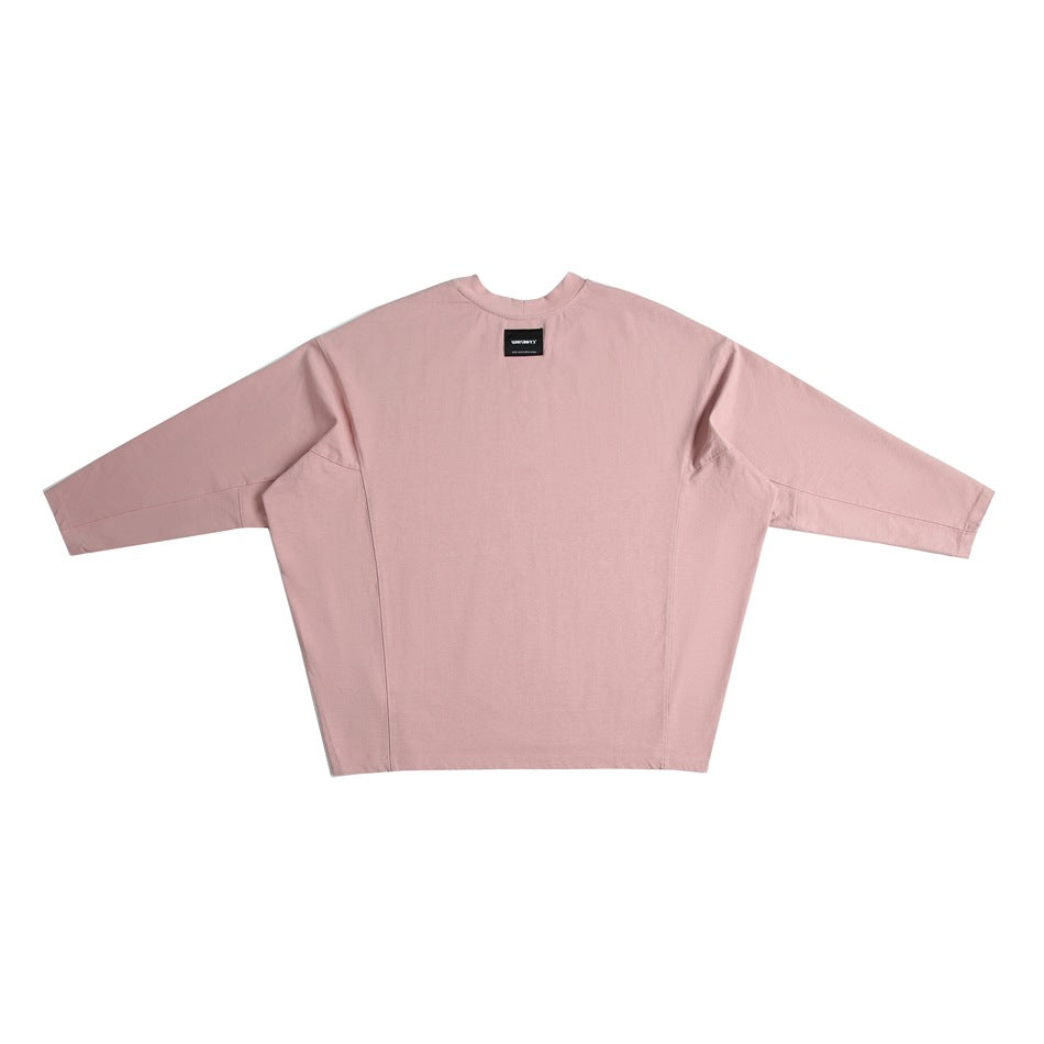 Pink long-sleeve oversized top back view with small black label at the neck, flat lay
