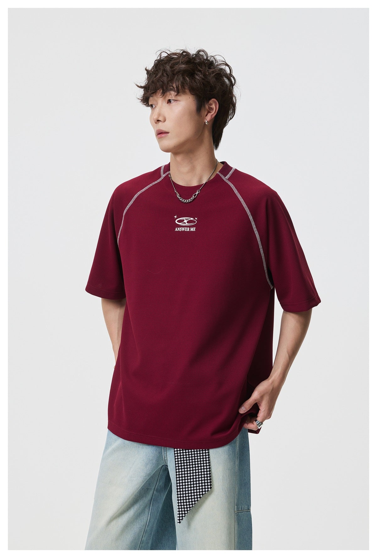 Model in a burgundy short-sleeve shirt with contrast seams, shown at an angle.