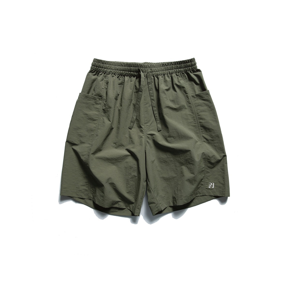 Army green shorts with elastic drawstring waistband, large side patch pockets and small embroidered N logo, flat lay