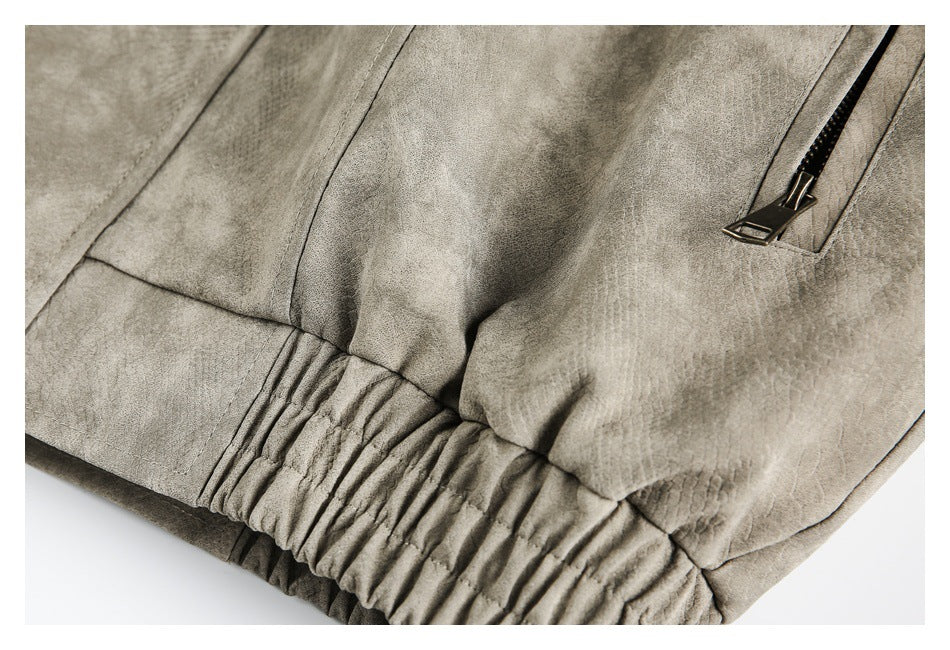 Close-up showing a taupe-gray jacket's gathered elastic hem and black zipper pocket.