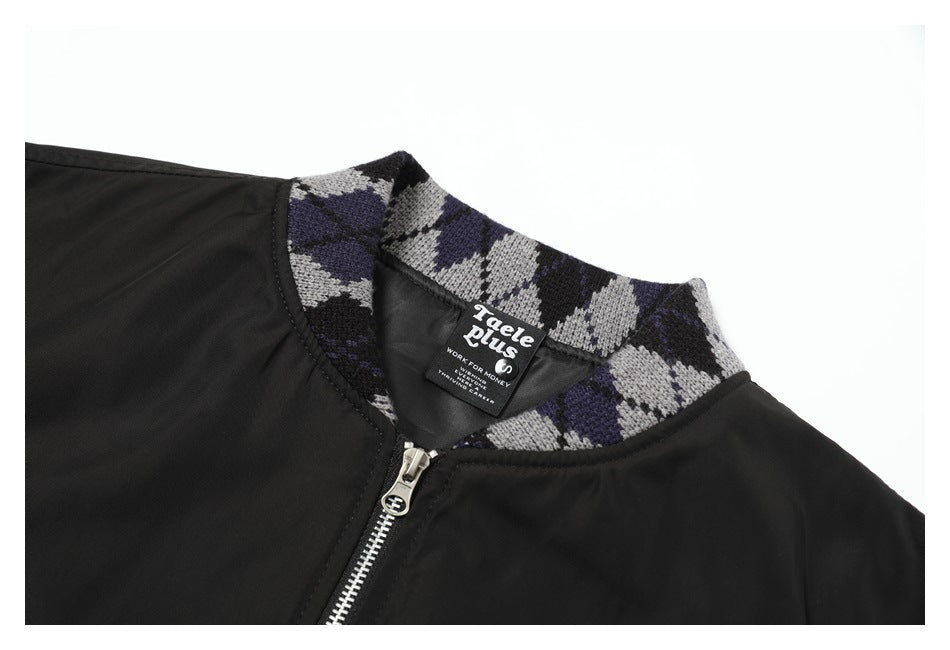 Close-up of a black jacket neckline with a gray, black, and purple patterned collar and front zipper.