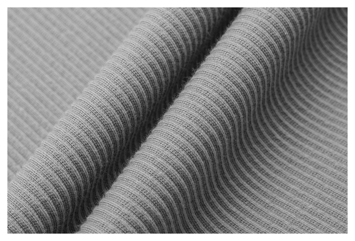 Macro close-up showing the fine ribbed texture of light gray fabric.