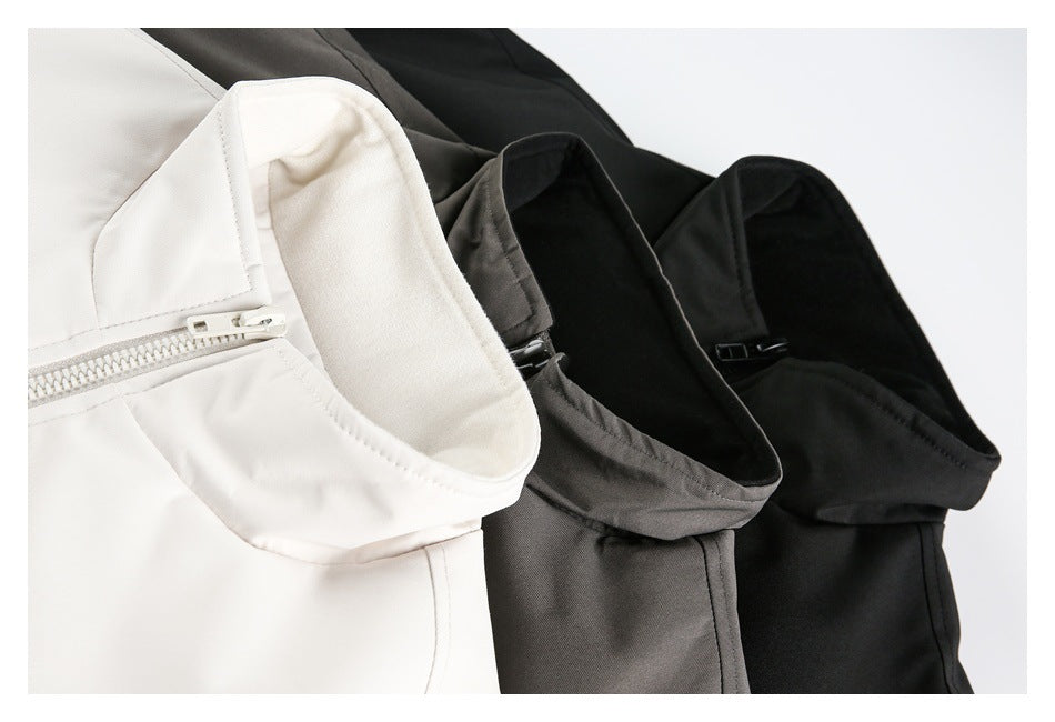 Close-up of jacket collars and zippers in off-white, charcoal gray, and black.