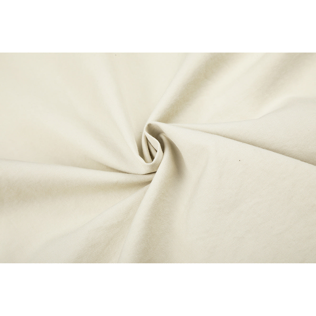 Close-up of off-white fabric gathered to show its fine diagonal weave.