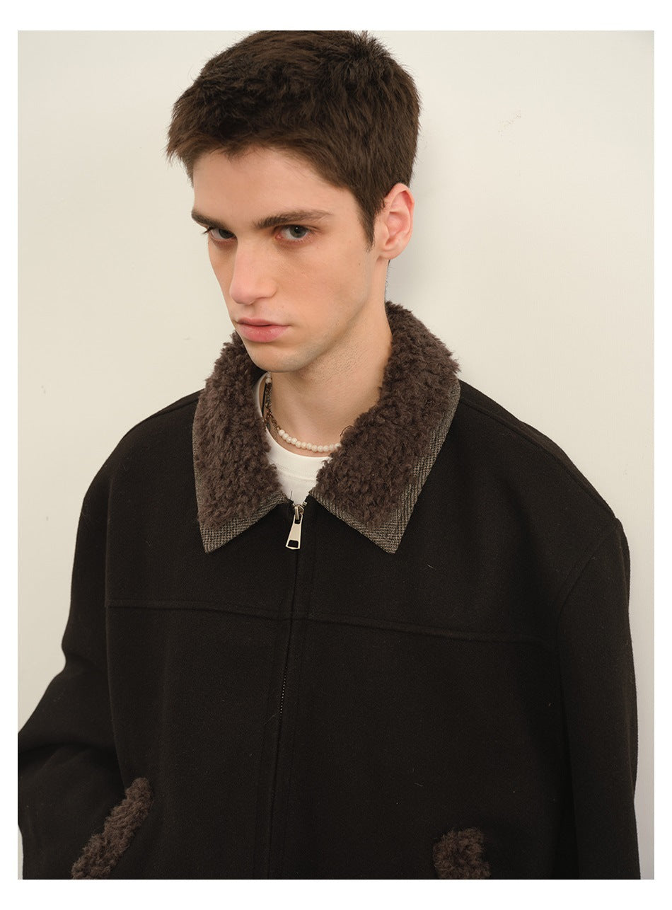 Close front view of a model wearing a black jacket with a brown textured collar and matching pocket trim.