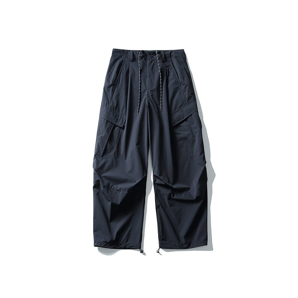 Navy wide-leg cargo pants flat lay with drawstring waist, flap cargo pockets and toggle drawstring hems