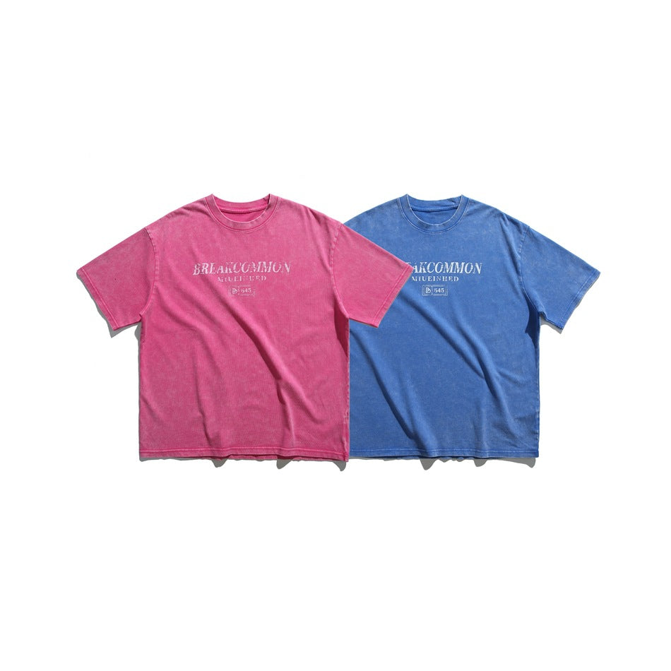 Two short-sleeve crew-neck T-shirts shown from the front, one pink and one blue, both with white chest graphics.