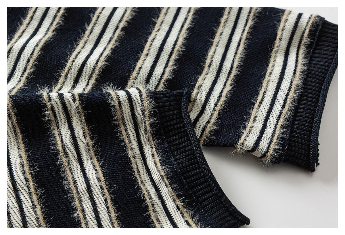 Close-up of a navy and cream striped knit sleeve with a ribbed cuff and fuzzy beige accents.