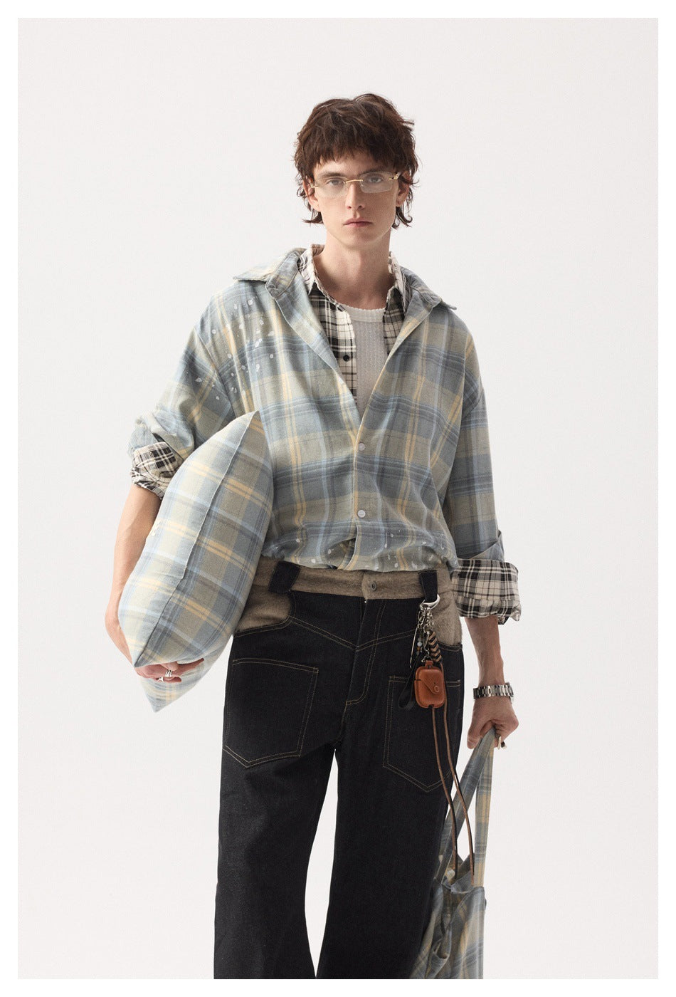 Model wearing a blue-gray and pale yellow plaid overshirt with white splatter details, shown from the front.