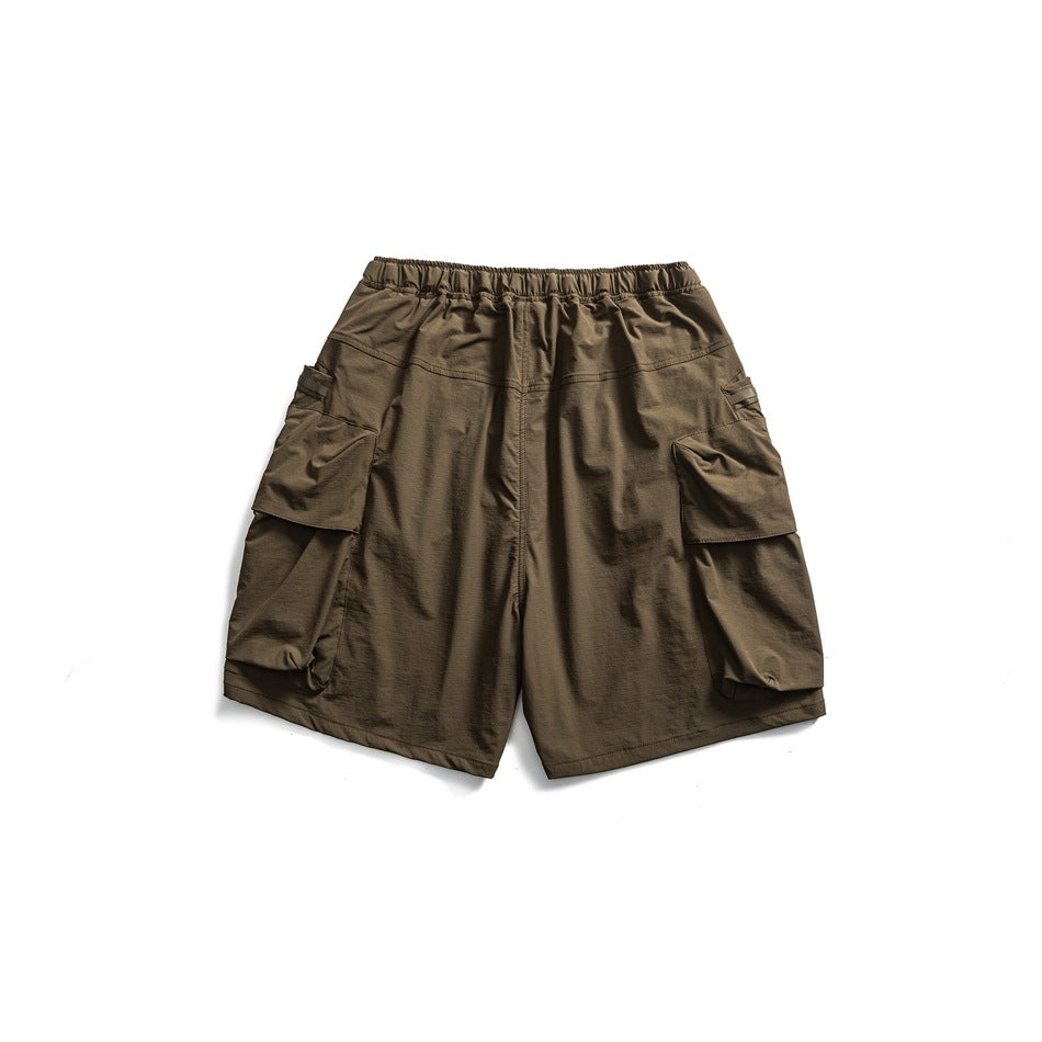 Olive-brown cargo shorts, front view, with an elastic waistband and large flap pockets on both sides.