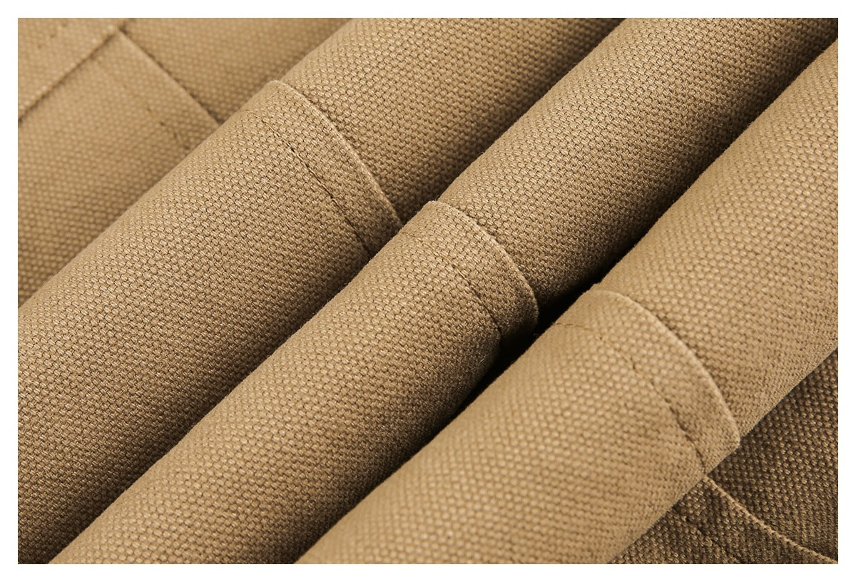 Macro view of folded tan garment fabric showing its woven texture and stitched edges.