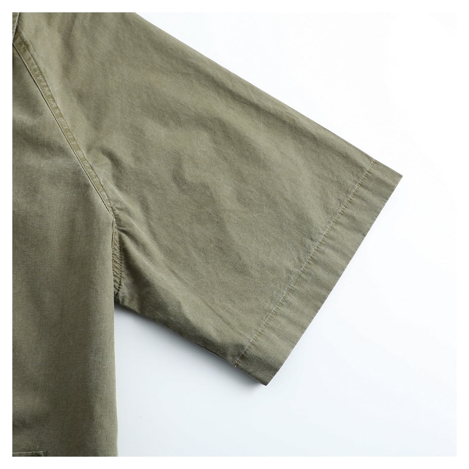 Close-up of an olive-gray garment's wide short sleeve and stitched cuff.